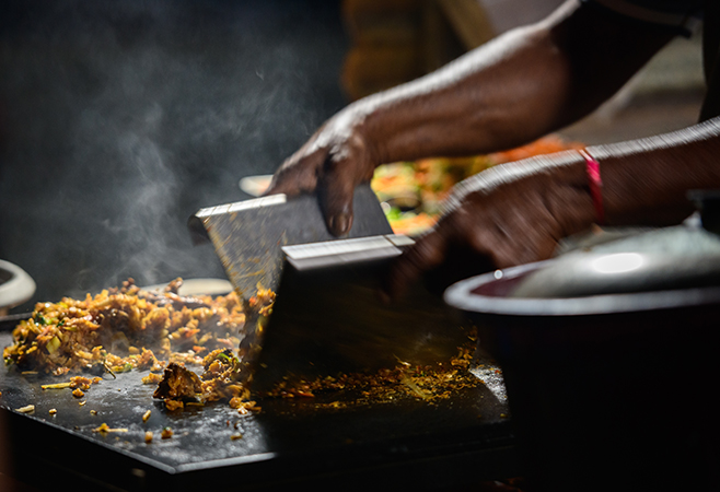 Kottu roti being chopped and mixed on a hot griddle — the heartbeat of Sri Lankan street cuisine