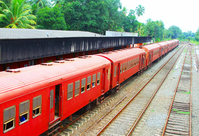 A classic red train of Sri Lanka Railways traveling from Colombo to Kandy