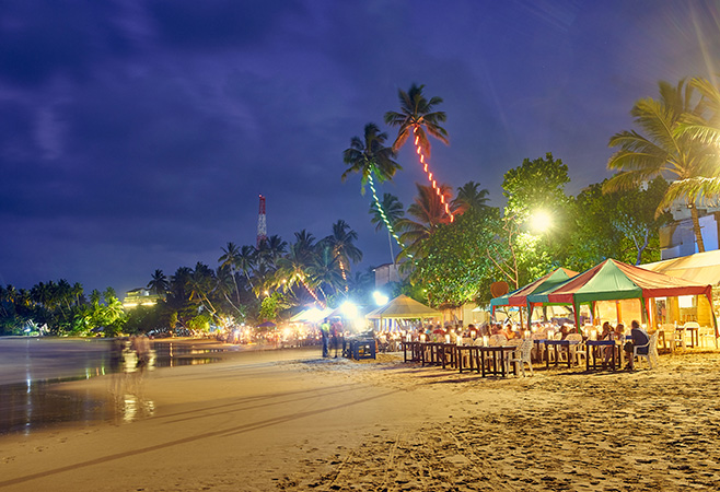 Tourists enjoying authentic Sri Lankan street food along the seaside