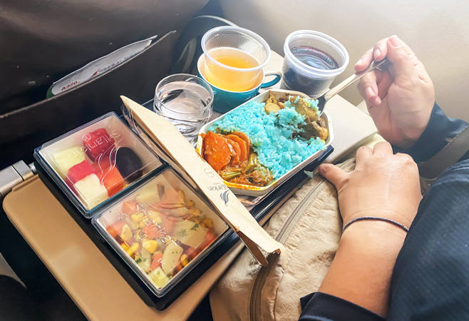 The international in-flight lunch served by SriLankan Airlines includes curry rice, fresh fruit, salad, and orange juice.